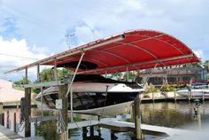 a boat tied up to a dock with a canopy over it