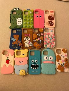 there are many cell phones with cartoon characters on them, all in different colors and shapes