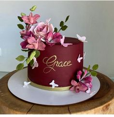 a red cake with pink flowers on top