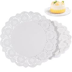 three white doily with a small cake on top