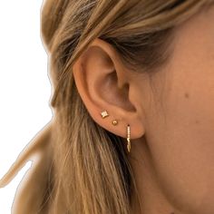 a close up of a woman's ear with two small gold stars on it