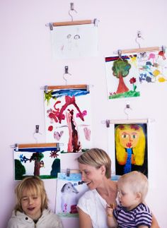 a woman and two children sitting in front of pictures