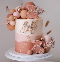 a pink and gold baby shower cake with teddy bears