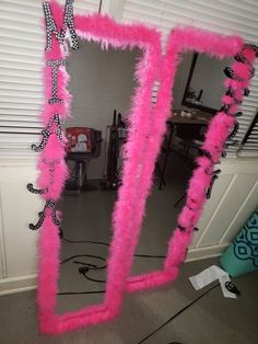 a mirror that has some pink feathers on it