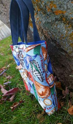 "A small baseball tote bag for boys. This little tote is perfect for boys to carry their toy cars in. Made from a fun light blue cotton print featuring baseballs, gloves, pennants, & hats. The handle is denim which will be nice & sturdy for him. Please note that it is a small tote bag & will not fit a school size folder. It only measures 8.5\" wide x 8.5\" tall. You can choose to have a matching coin purse measuring 3.25\" x 5\" The tote will have pockets on the inside and a magnetic Casual Blue Bags, Baseball Tote Bag, Toddler Sports, Baseball Bag, Toy Bags, Small Tote Bag, Toy Cars, Small Tote, Preschool