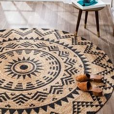 a pair of brown shoes sitting on top of a black and white rug in a living room