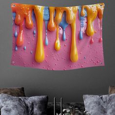 a wall hanging on the side of a bed covered in colorful liquid drops and water