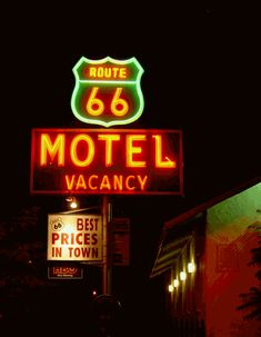 the neon sign for route 66 motel is lit up in red, white and green