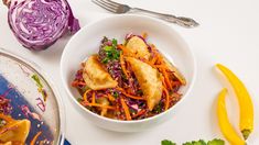 a white bowl filled with food next to two yellow peppers and an onion wedges