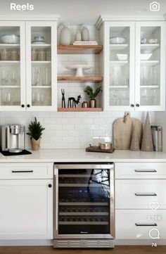 a kitchen with white cabinets and glass front cupboards is featured on the instagram page