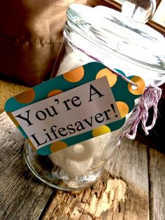 a jar filled with white balls sitting on top of a wooden table