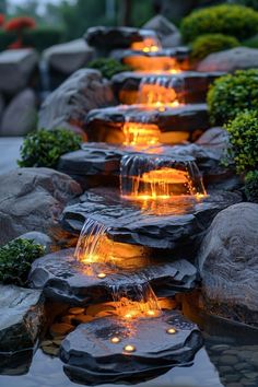 an outdoor water feature with rocks and lights