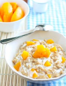 a bowl of oatmeal with peaches and milk on a tablecloth