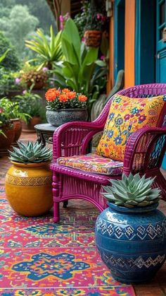 an outdoor area with potted plants and colorful rugs on the ground next to a blue door