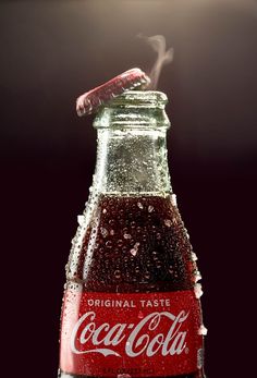 a coca - cola bottle is shown with steam coming out of the top and bottom