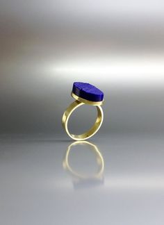 Raw stone oval blue Lapis Lazuli ring with solid 18K gold. Unique gift for her, girlfriend, wife, September and December birthstone, anniversary gift. The sides of this raw stone ring are polished to secure a firm hold and give a the opportunity to cut a geometrical shape. It is set in 18K gold with a 4mm / 0.15inches band and a small rim embracing the stone. All our stones are natural stones and our jewelry is handmade, very slight differences may occur in color and size. Please note the size s Yellow Gold Rings With Natural Stones For Gift, 14k Gold Rings With Natural Stones For Gift, Oval Yellow Gold Rings With Natural Stones, Modern Lapis Lazuli Jewelry As Gift, Oval 14k Gold Rings With Natural Stones, Elegant Raw Stone Jewelry For Anniversary, Wedding Blue Rings With Natural Stones, Elegant Blue Ring With Natural Stones, Minimalist Oval Blue Ring