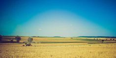 an open field with hay being harvested