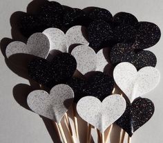 black and white heart picks are arranged on toothpicks with glitter hearts in the middle