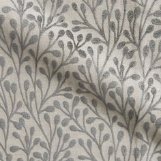 a close up view of a fabric with grey leaves on it