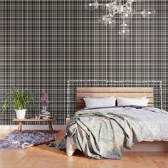 a bedroom with black and white checkered wallpaper, a chandelier and a bed