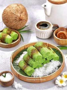 some food that is sitting on a plate next to cups and saucers with coconuts in the background