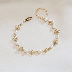 This dainty wire-wrapped pearl bracelet contains beautiful beads wire wrapped on a 14K gold-filled or sterling silver chain. This bracelet makes a great birthday or Christmas gift! Also available in anklet sizes! Measure your wrist or ankle to ensure the proper fit! There are four sizes available. The standard size bracelet has rosary chain of 6 inches with a 1.5 inch extension chain (7.5 inches total - fits wrists from 6 to 7.4 inches). The extended size bracelet has 7.5 inches of rosary chain Cheap Pearl Bracelet For Gifts, Gold Bracelet Pearl, Elegant White Wire Wrapped Pearl Bracelet, Delicate Beaded 14k Gold-filled Bracelets, Dainty Pearl Bracelet For Jewelry Making, Dainty Pearl Charm Bracelet Adjustable, Delicate Gold Chain Bracelet With Pearl Charm, Handmade Delicate Pearl Bracelet, Elegant Gold Wire-wrapped Bracelet