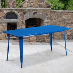 a blue table sitting in front of a brick oven with an open fire place next to it