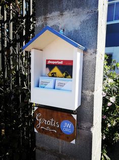 a mailbox that is on the side of a building with some signs attached to it