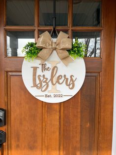 a wooden door with a sign that says the islers on it and a bow