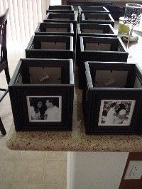 there are many framed pictures on the counter in front of some chairs and a table