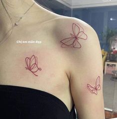 two butterflies on the back of a woman's shoulder, both with red ink