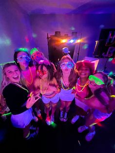 a group of young women standing next to each other in front of a purple light