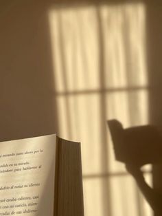 an open book sitting on top of a table next to a window