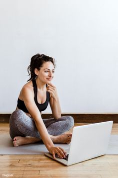 a woman is sitting on the floor with her laptop