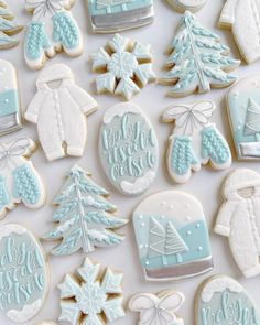 christmas cookies decorated with blue frosting and white icing on top of a table