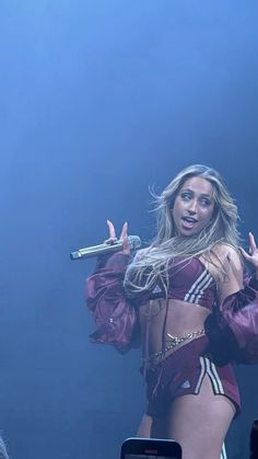 a woman in a purple outfit holding a microphone