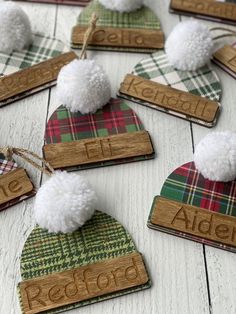 wooden name tags with pom - poms are laid out on a white table