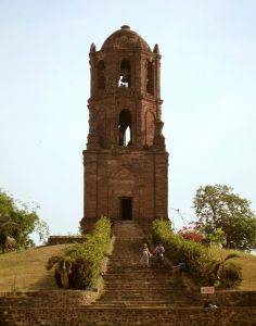 two people walking up some steps to a tower