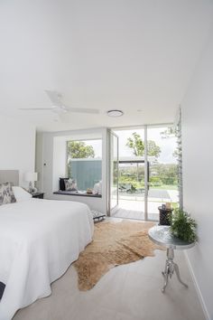 a bedroom with a large bed sitting next to a sliding glass door that leads outside