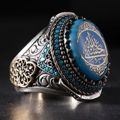 Hasbi Allah Silver Men's Ring Model Our silver men's ring model, which we carefully designed from the 'OUR PATTERNED MODEL' collections, is decorated with amber and micro-stones and is embroidered with the art of engraving. On the upper part, the ARIZONA FIRUZE stone is carved with the art of carving, and on the inside, 'HASBI ALLAH VENIMEL VEKIL' is written with calligraphy. In addition, special works are carried out for our customers on the upper part. Turquoise Silver Mens Ring, Islamic Gift Arabian Jewelry Men Bands, Engraved Turquoise Rings As Gift, Hasbi Allah, Ottoman Jewelry, Stone Rings For Men, Sadio Mane, Silver Mens Ring, Unique Silver Rings, Ring Model