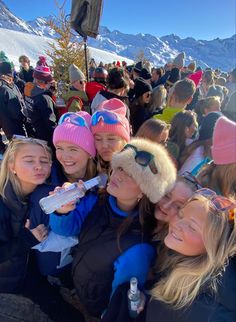 a group of young women standing next to each other on top of a snow covered slope