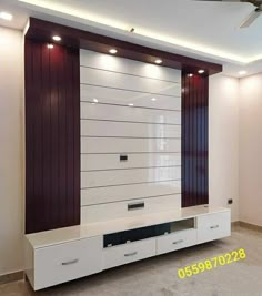 an empty living room with white furniture and red accents on the wall, along with dark wood paneling