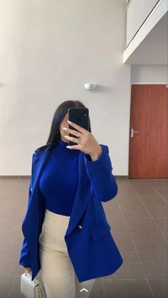 a woman taking a selfie with her cell phone in front of her face and wearing a blue blazer