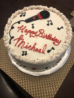 a birthday cake with musical notes and a microphone on it that says happy birthday michael