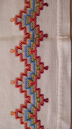 a close up of a piece of cloth with different colored stitchs on the side