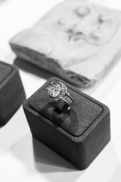 an engagement ring sits in a box on the table next to other jewelry boxes and napkins