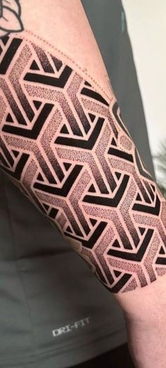 a man's arm with black and grey geometric designs on the forearm, hand and leg