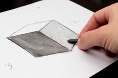 a person is drawing on paper with a pencil