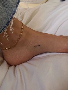 a person's foot with a small tattoo on the side of their left leg