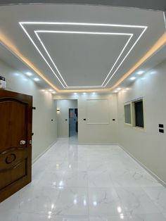 an empty room with white marble flooring and recessed lighting on the ceiling above